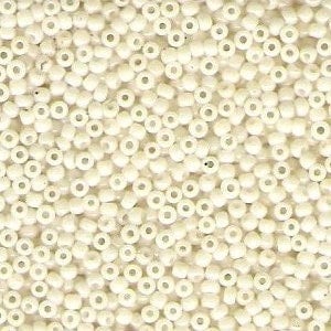 May include: Close-up of a pile of small, off-white seed beads. The beads are cylindrical with a hole running through the center. They are tightly packed together, creating a textured surface. The beads are uniform in size and shape.