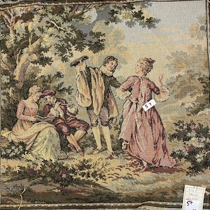 Puede incluir: Un tapiz que representa cuatro figuras en un entorno boscoso. Dos figuras están sentadas en una roca, una tocando una flauta, mientras que la otra sostiene un libro. Otras dos figuras están de pie, una sosteniendo un instrumento musical, y la otra con las manos levantadas. El tapiz tiene una gama de colores marrón, verde y beige.