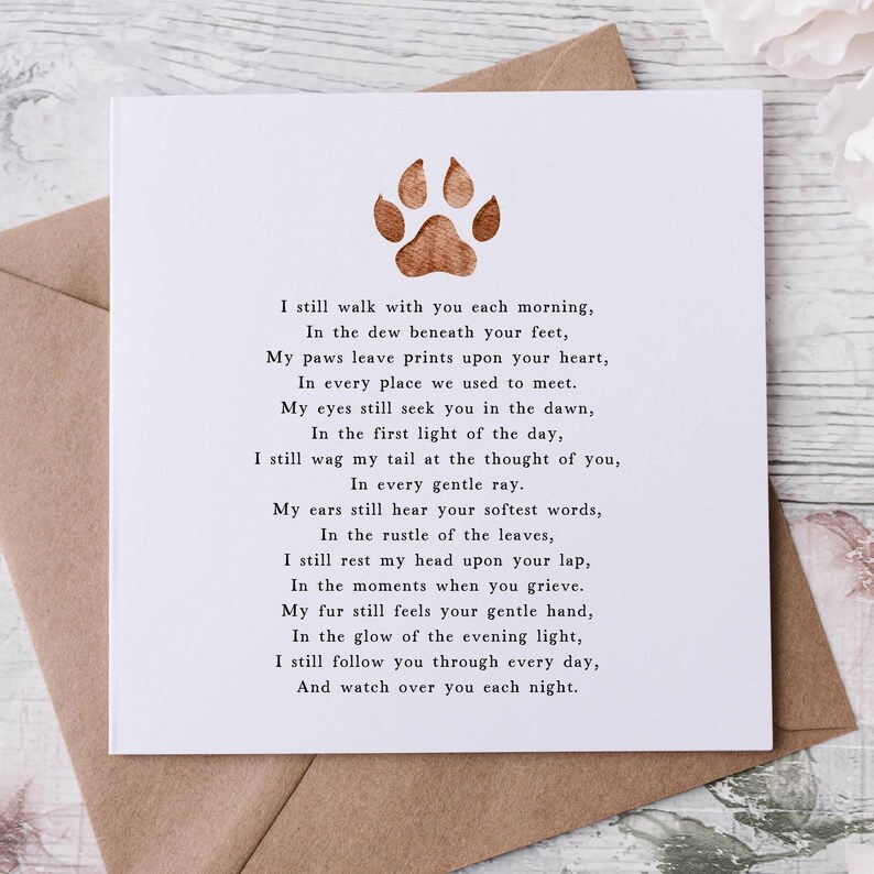 May include: A white card with a brown paw print and a poem about a pet that has passed away. The poem reads, "I still walk with you each morning, In the dew beneath your feet, My paws leave prints upon your heart, In every place we used to meet. My eyes still seek you in the dawn, In the first light of the day, I still wag my tail at the thought of you, In every gentle ray. My ears still hear your softest words, In the rustle of the leaves, I still rest my head upon your lap, In the moments when you grieve. My fur still feels your gentle hand, In the glow of the evening light, I still follow you through every day, And watch over you each night."