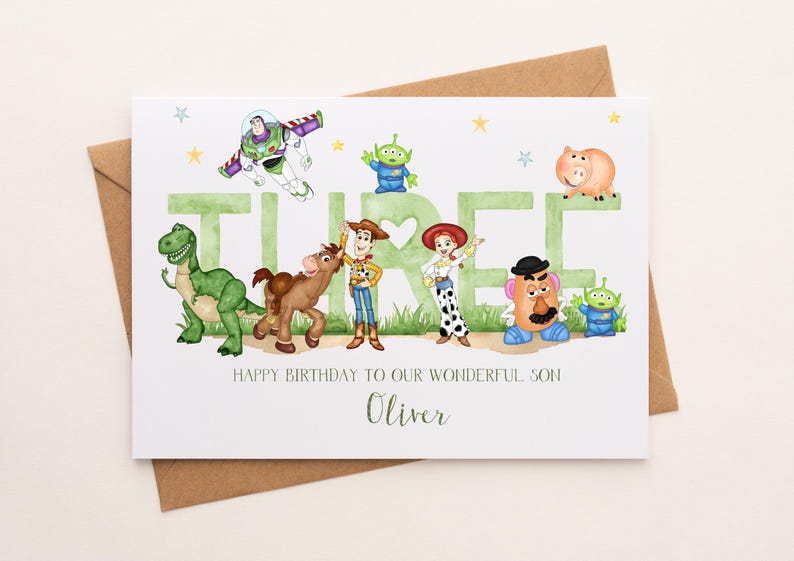 May include: A white birthday card featuring watercolor illustrations of Toy Story characters including Buzz Lightyear, Woody, Jessie, Rex, Bullseye, Mr. Potato Head, and aliens. The word THREE is in large green letters. Text reads: HAPPY BIRTHDAY TO OUR WONDERFUL SON Oliver.