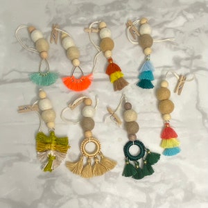 May include: Eight handmade felt ball ornaments with wooden beads and colorful tassels. Each ornament is attached to a wooden clothespin.