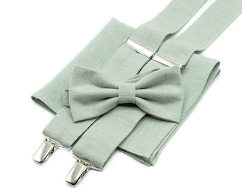 Puede incluir: Una pajarita y tirantes a juego de lino verde salvia con clips plateados. La pajarita y los tirantes están colocados sobre un pañuelo de bolsillo de lino verde salvia.