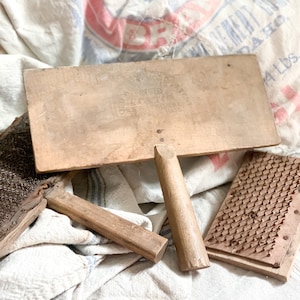May include: A vintage wooden wool carder with a handle and a metal comb. The carder has a label that reads "Open Work Patent No. 1010, G.C. Thomas & Co., Mass."