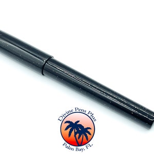 May include: A black fountain pen with a speckled, glittery finish. The pen has a cap and a sleek, modern design. The logo for Divine Pens Plus is visible in the lower right corner.