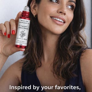 Puede incluir: Una botella de aceite de perfume roll-on rojo con texto blanco y una ilustraci&oacute;n floral es sostenida por una persona. La botella dice "ROLL-ON FRAGRANCE OIL" y "Our Impression of Hibiscus Mahajad". El texto "Inspired by your favorites, affordable for everyone" tambi&eacute;n es visible.