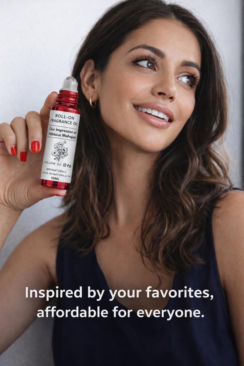 Puede incluir: Una botella de aceite de perfume roll-on rojo con texto blanco y una ilustraci&oacute;n floral es sostenida por una persona. La botella dice "ROLL-ON FRAGRANCE OIL" y "Our Impression of Hibiscus Mahajad". El texto "Inspired by your favorites, affordable for everyone" tambi&eacute;n es visible.