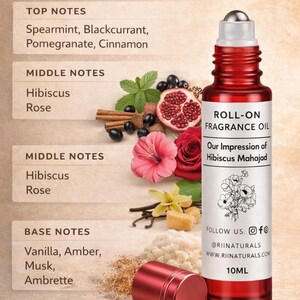 Puede incluir: Botella de aceite de perfume roll-on roja con tapa plateada, etiquetada como "Our Impression of Hibiscus Mahajad". La imagen incluye ingredientes como menta, hibisco y vainilla. La botella es de 10 ml.