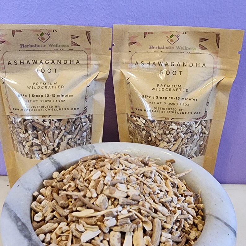 May include: Two brown paper pouches of dried ashwagandha root, labeled "Ashwagandha Root" with the text "Premium Wildcrafted" and "85&deg;c | Steep 10-15 minutes". A white ceramic mortar and pestle is filled with the dried root.