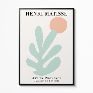 May include: A minimalist art print featuring a stylized green leaf and a peach-colored circle. The print is titled "Henri Matisse" and includes the text "Aix en Provence, Pavillon de Vendome".
