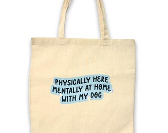 May include: A beige tote bag with a blue and white graphic that says "Physically here, mentally at home with my dog".