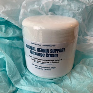 May include: White jar with a blue label that reads "100% NATURAL - HANDCRAFTED INGUINAL HERNIA SUPPORT Massage Cream Apply a thin layer and Massage afflicted area 2-3 times a day or as needed Cell salts, Bach flowers, Oligo Synergistic Formula"