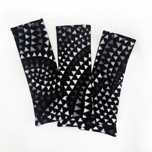 May include: Three black and white patterned fabric armrests with a geometric design. The armrests are made of a soft, plush fabric and have a black trim.