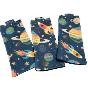 May include: Three blue fleece arm warmers with a space-themed print featuring planets, stars, and rockets.