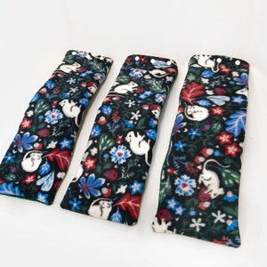 May include: Three black fleece fabric tubes with a white mouse and floral print. The tubes are lined with green fabric.