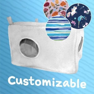 May include: A white, cube-shaped pet bed with a circular opening and three fabric pattern options: floral, striped, and unicorn-themed. The word "Customizable" is printed in white on a blue background.