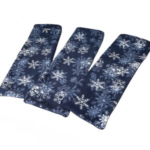 May include: Three blue fleece fabric rectangular heat packs with a white snowflake pattern.