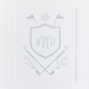 May include: A framed watercolor print of a golf-themed crest with the initials "WWD" in a shield surrounded by golf clubs and golf balls.