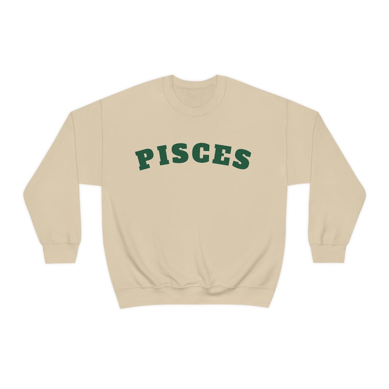 May include: A beige sweatshirt with the word "PISCES" printed in green on the front.
