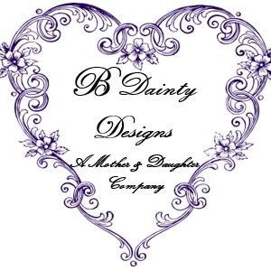 Puede incluir: Un dise&ntilde;o morado en forma de coraz&oacute;n con detalles florales y el texto "B Dainty Designs, A Mother & Daughter Company". El dise&ntilde;o presenta remolinos ornamentados e ilustraciones de flores delicadas, perfecto para un logotipo o emblema.