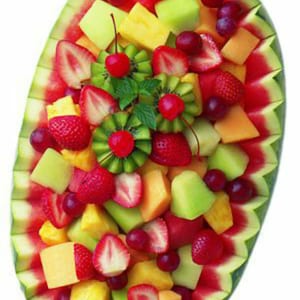 Puede incluir: Un cuenco de c&aacute;scara de sand&iacute;a lleno de una variedad de fruta fresca, incluyendo sand&iacute;a, mel&oacute;n cantalupo, mel&oacute;n de miel, fresas, pi&ntilde;a, kiwi, uvas y cerezas.