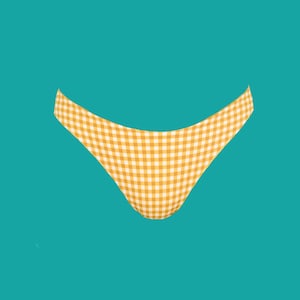 May include: A yellow and white gingham patterned bikini bottom against a teal background. The swimwear bottom has a curved shape and is made of a lightweight fabric. The classic check pattern is a timeless design.