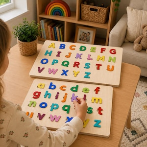 May include: Two rectangular wooden boards featuring the alphabet in colorful, removable letters. The top board displays uppercase letters A through Z, while the bottom board shows lowercase letters a through z in various bright colors.