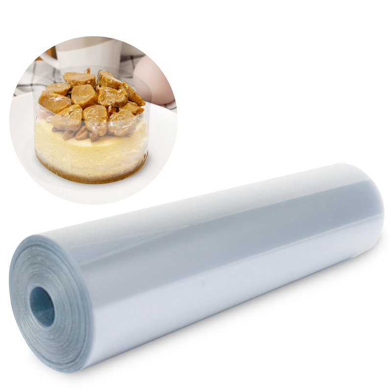 May include: A roll of clear, food-grade plastic wrap, ideal for wrapping cakes and other baked goods. The image also shows a small cheesecake topped with nuts and caramel.