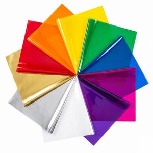 May include: A vibrant array of colorful sheets arranged in a circular pattern. The colors include gold, silver, white, red, orange, yellow, green, blue, purple, and pink. The sheets appear to be made of a shiny, reflective material.