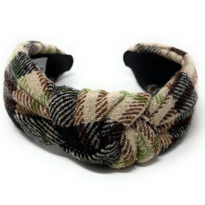 May include: A knotted headband with a plaid pattern in black, brown, beige, and green.