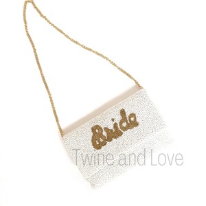 As if being the Bride could get any sweeter, here is a gorgeous handbag to carry all your things throughout this exciting occasion. You'll love these gorgeous beaded clutch, buy for yourself or/and give as the perfect gift. Hand sewn seed beads with Bride across the front and has a magnetic button snap closure. Features an optional gold chain that converts into a shoulder purse.