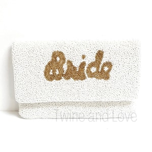 As if being the Bride could get any sweeter, here is a gorgeous handbag to carry all your things throughout this exciting occasion. You'll love these gorgeous beaded clutch, buy for yourself or/and give as the perfect gift. Hand sewn seed beads with Bride across the front and has a magnetic button snap closure. Features an optional gold chain that converts into a shoulder purse.