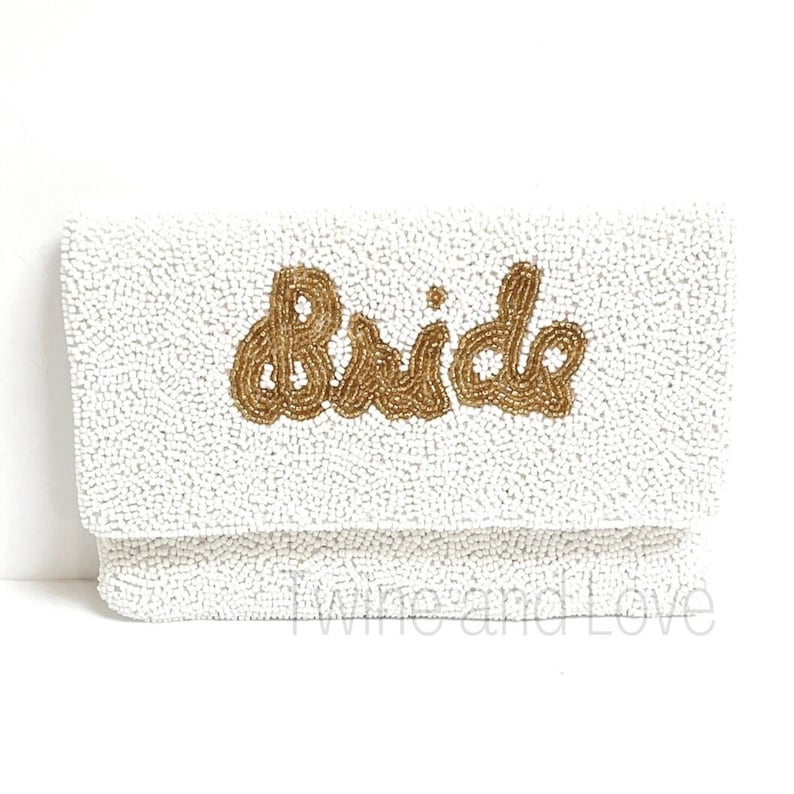 As if being the Bride could get any sweeter, here is a gorgeous handbag to carry all your things throughout this exciting occasion. You'll love these gorgeous beaded clutch, buy for yourself or/and give as the perfect gift. Hand sewn seed beads with Bride across the front and has a magnetic button snap closure. Features an optional gold chain that converts into a shoulder purse.