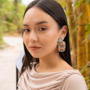 Close-up of a woman wearing stylish earrings in a natural setting.