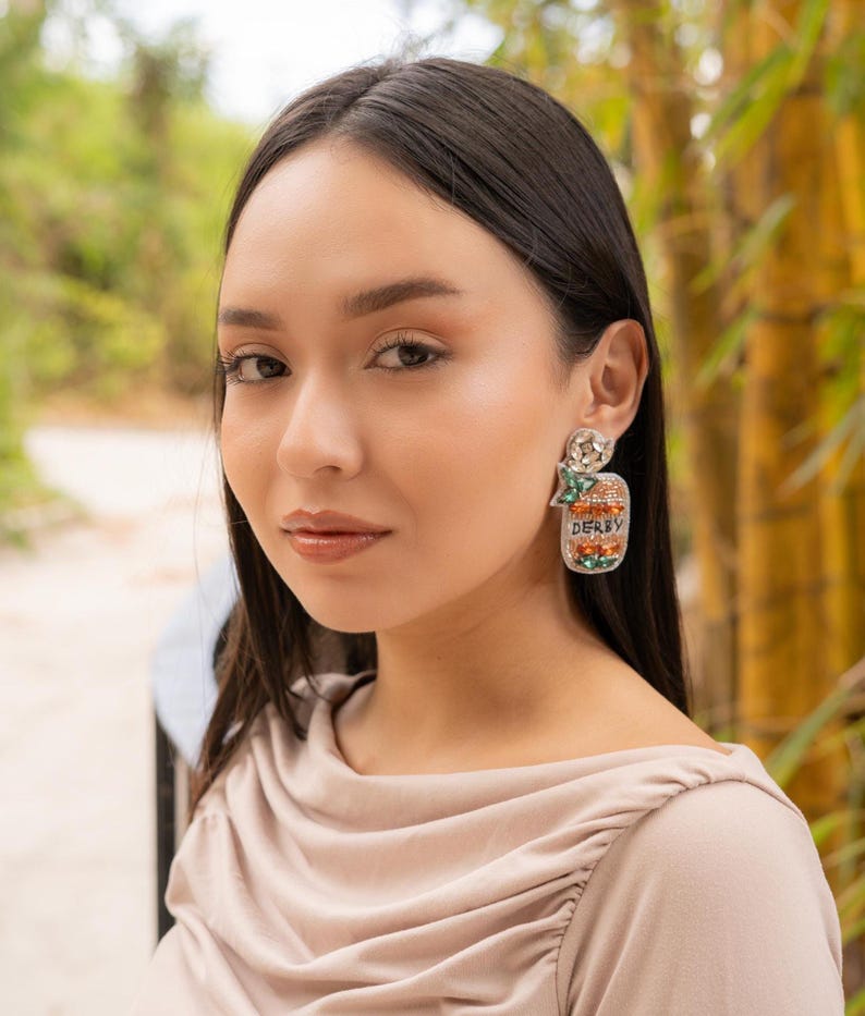 Close-up of a woman wearing stylish earrings in a natural setting.