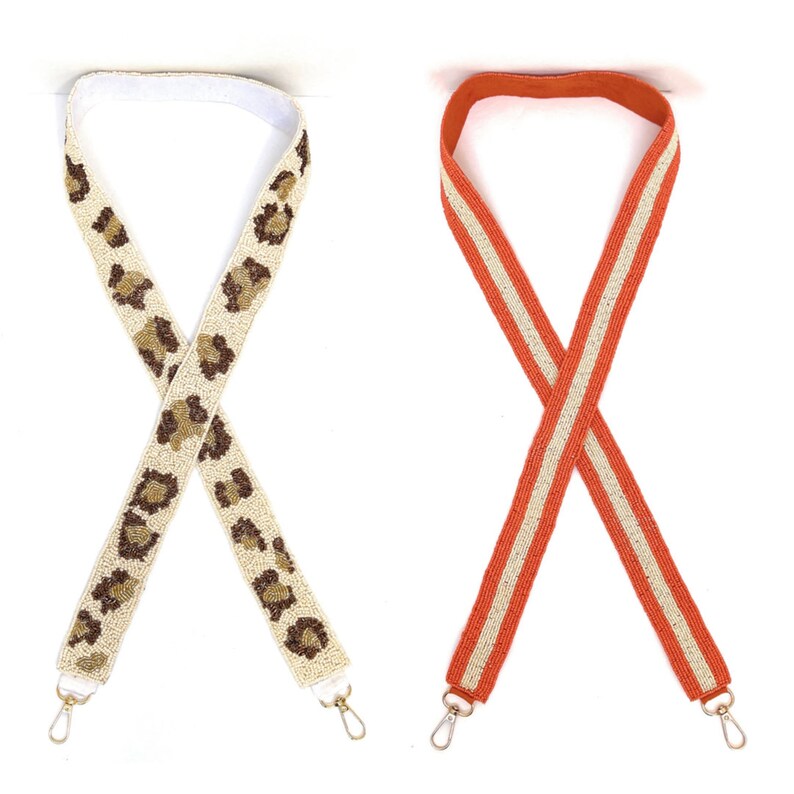 Pu&ograve; includere: Due cinturini perlati, uno con un motivo a stampa leopardata in marrone e beige, l'altro con strisce arancioni e beige.
