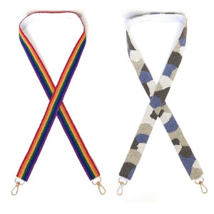 Pu&ograve; includere: Due cinturini per borsa in perline, uno con un motivo arcobaleno e l'altro con un motivo mimetico. Entrambi i cinturini hanno fibbie in metallo dorato.