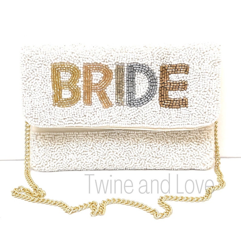 As if being the Bride could get any sweeter, here is a gorgeous handbag to carry all your things throughout this exciting occasion. You'll love these gorgeous beaded clutch, buy for yourself or/and give as the perfect gift. Hand sewn seed beads with Bride across the front and has a magnetic button snap closure. Features an optional gold chain that converts into a shoulder purse.