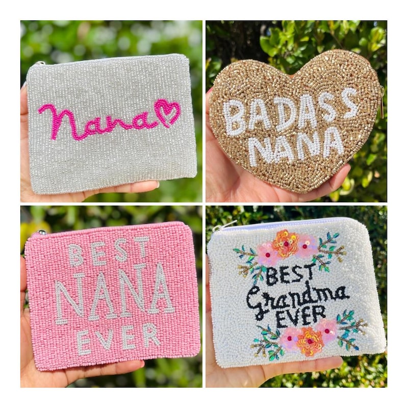 May include: Four beaded pouches in the image. One is silver with "Nana" in pink, another is heart-shaped with "Badass Nana", a pink one with "Best Nana Ever", and a white one with "Best Grandma Ever" with floral accents.