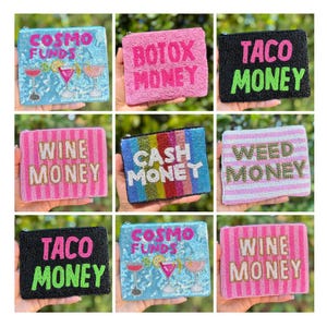 May include: A collection of beaded coin purses in various colors, each featuring a different phrase. Phrases include "COSMO FUNDS," "BOTOX MONEY," "TACO MONEY," "WINE MONEY," "CASH MONEY," and "WEED MONEY." The purses have a zipper closure.
