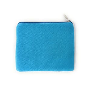 May include: A square, turquoise-colored pouch with a zipper closure. The pouch is made of a textured fabric and has a matching blue zipper and trim. The zipper pull is silver-colored.