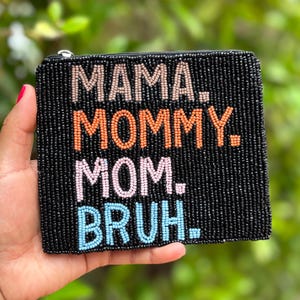 Puede incluir: Bolsa negra con cremallera de cuentas con las palabras "MAMA. MOMMY. MOM. BRUH." en cuentas de colores.