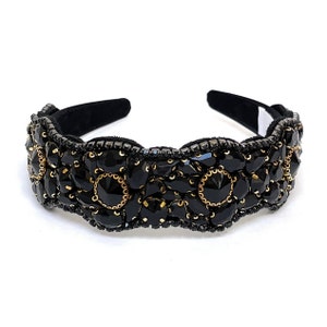 May include: Black headband with a decorative design of black and gold beads. The headband is made of a soft, flexible material and is perfect for adding a touch of elegance to any outfit.