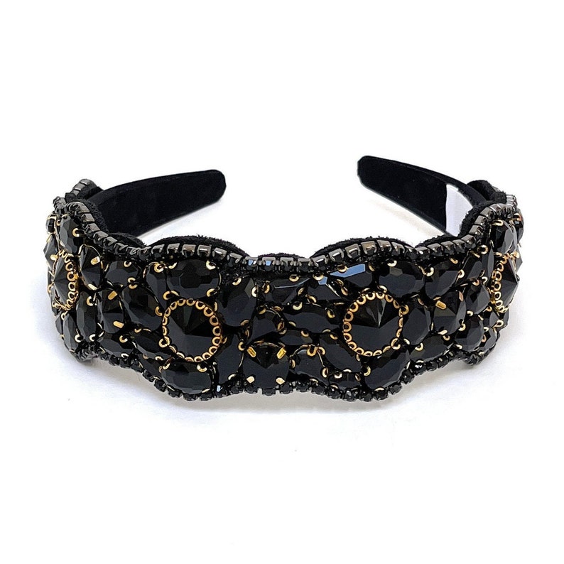 May include: Black headband with a decorative design of black and gold beads. The headband is made of a soft, flexible material and is perfect for adding a touch of elegance to any outfit.