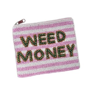May include: A beaded coin purse with a pink and white striped pattern. The words "WEED MONEY" are spelled out in green beads. The purse has a small zipper with a brown pull.