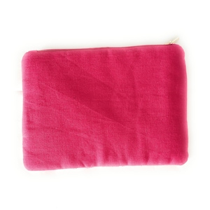 May include: A bright pink zippered pouch made of a soft, textured fabric. The pouch is ideal for storing small items like makeup, jewelry, or electronics.