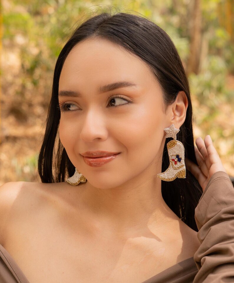 Close-up of a woman wearing stylish boot-shaped earrings with a star accent.
