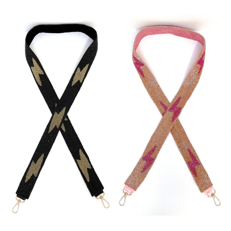 Pu&ograve; includere: Due cinturini per borsa in perline con motivi di fulmini dorati e rosa. Il cinturino a sinistra &egrave; nero e il cinturino a destra &egrave; beige.