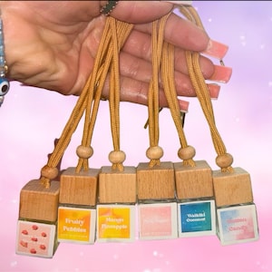 Puede incluir: Seis pequeños ambientadores de coche de madera con etiquetas coloridas y diferentes aromas. Los aromas son Strawberry Shortcake, Fruity Pebbles, Mango Pineapple, Pink Sugar, Waikiki Coconut y Cotton Candy.