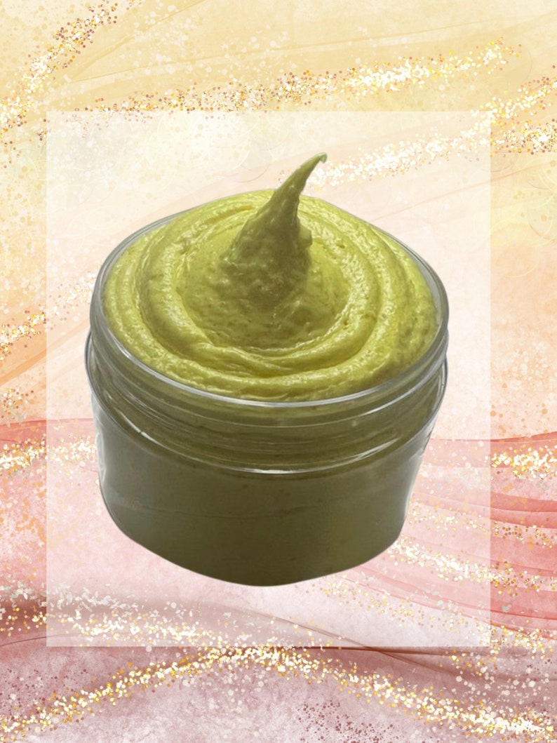 May include: A jar of light green, creamy product with a swirl design and a pointed top. The clear jar sits against a soft, abstract background with gold glitter accents. The product appears to be a skincare item.