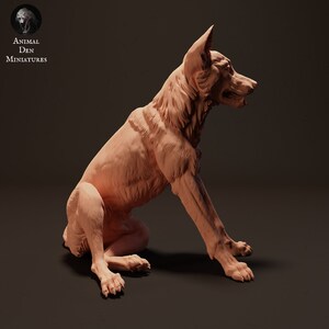 May include: A detailed, hand-painted miniature of a German Shepherd dog sitting with its head turned to the side. The miniature is made of a light brown, clay-like material.